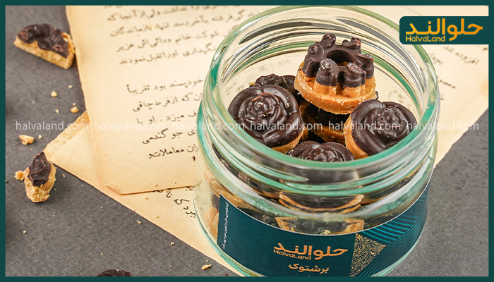 برس‌توک (حلوا شکلاتی) هلوالند در ظرف شیشه‌ای، در کنار متون قدیمی